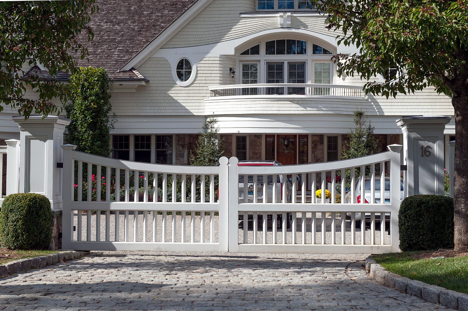 white wooden gate matches the style of a white house