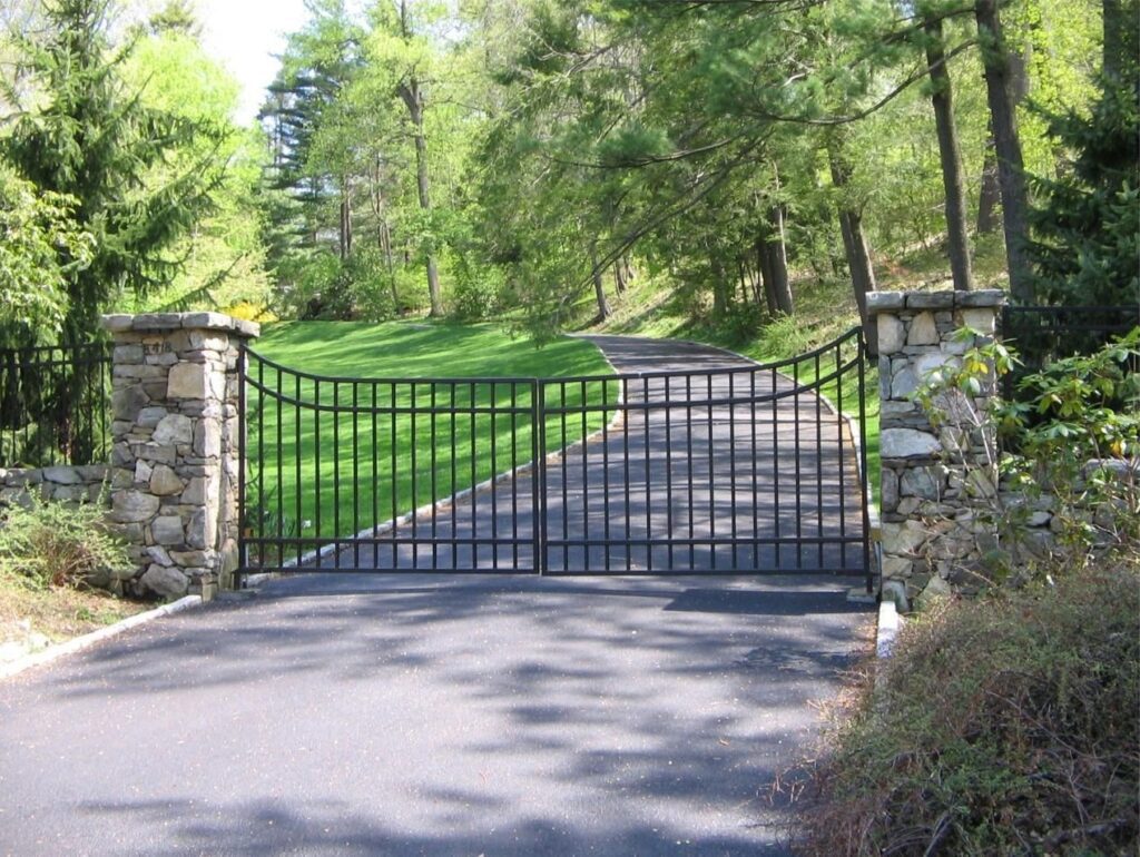 Sloping Iron Swing Gate with Stone Pillars