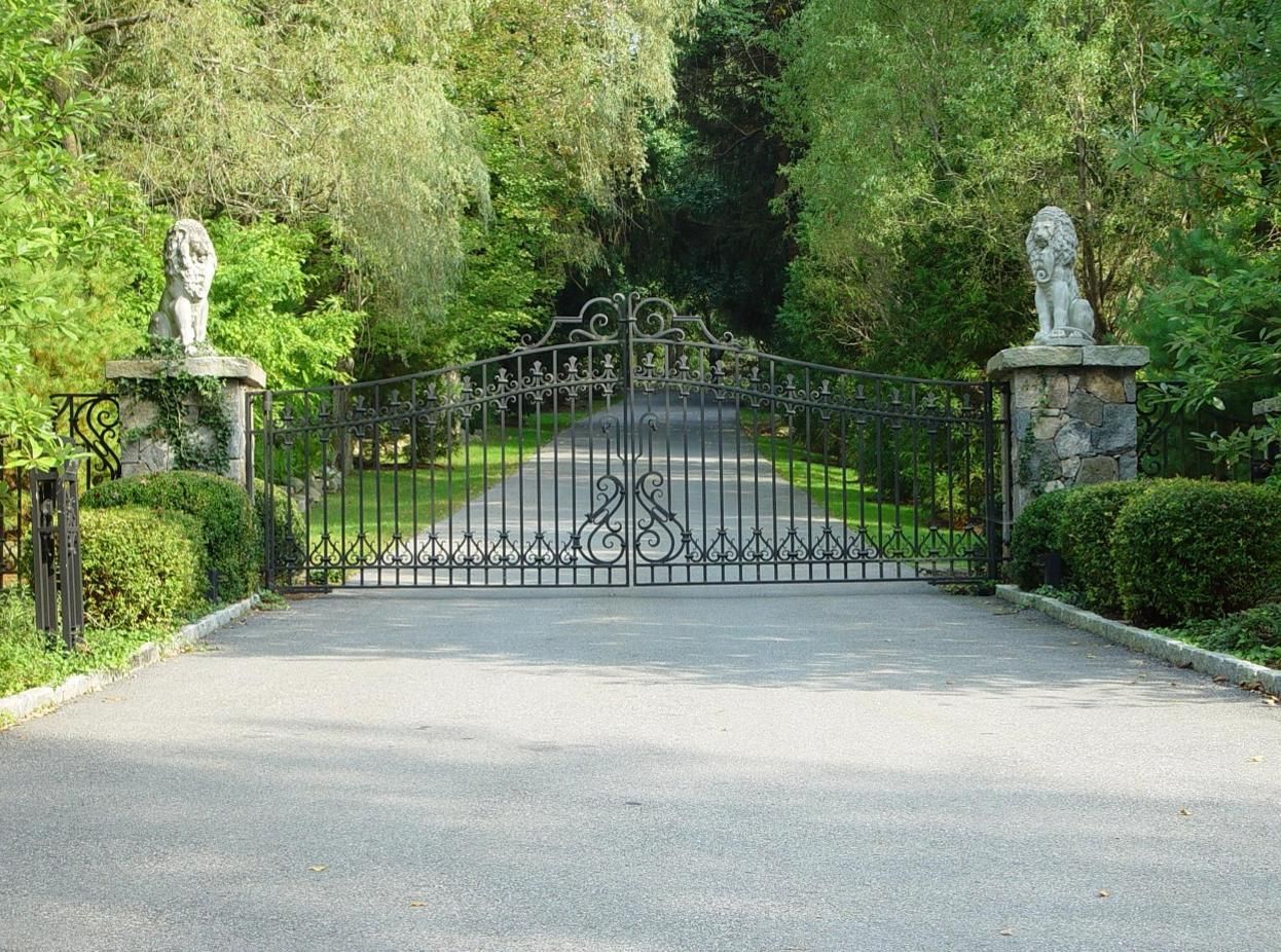 Wrought iron driveway gate with lion statues