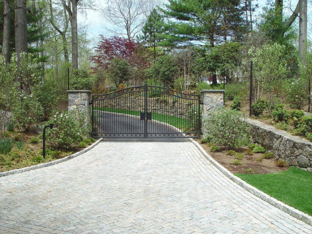 Metal Driveway Gate with Stone Pillars on a Sloping Drive