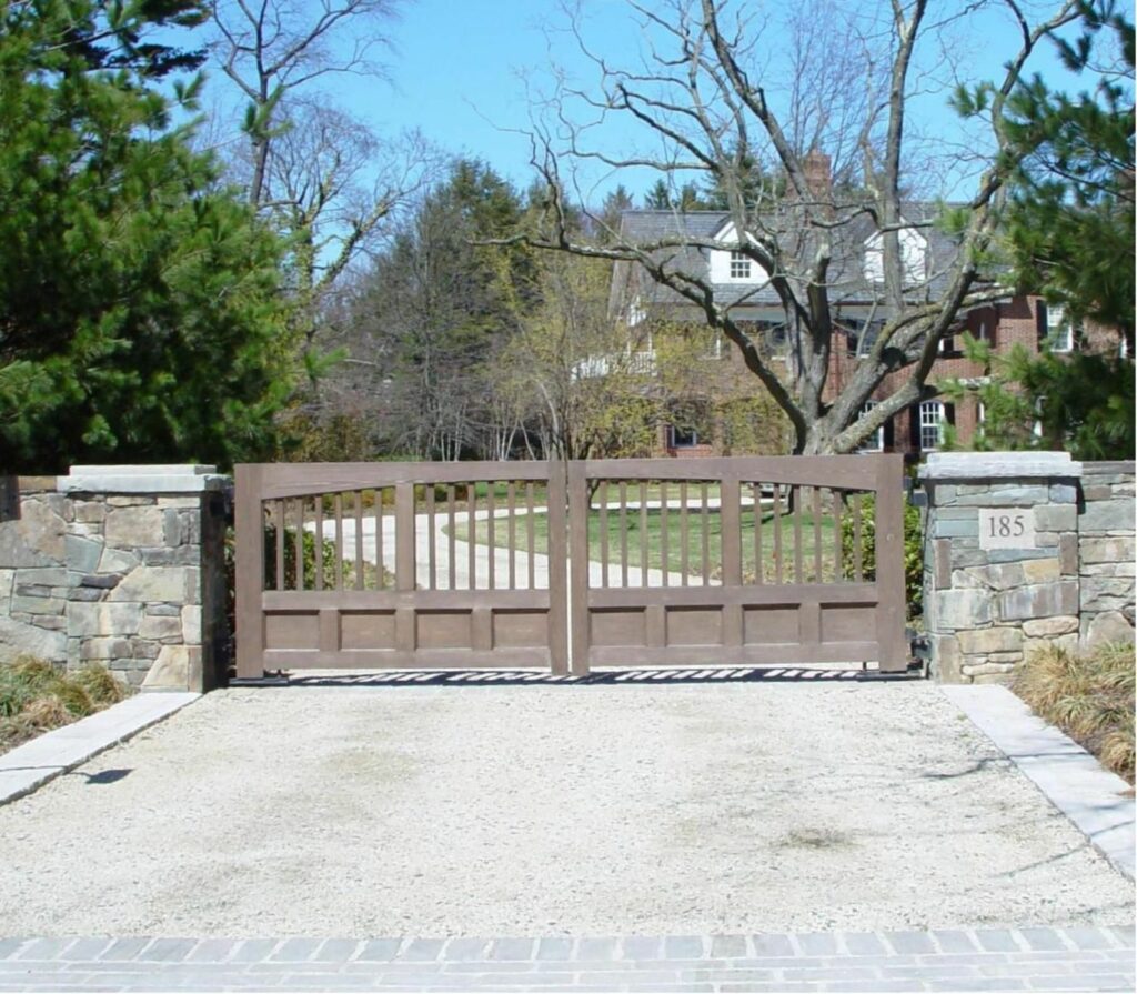 Wooden automated driveway gate with stone pillars