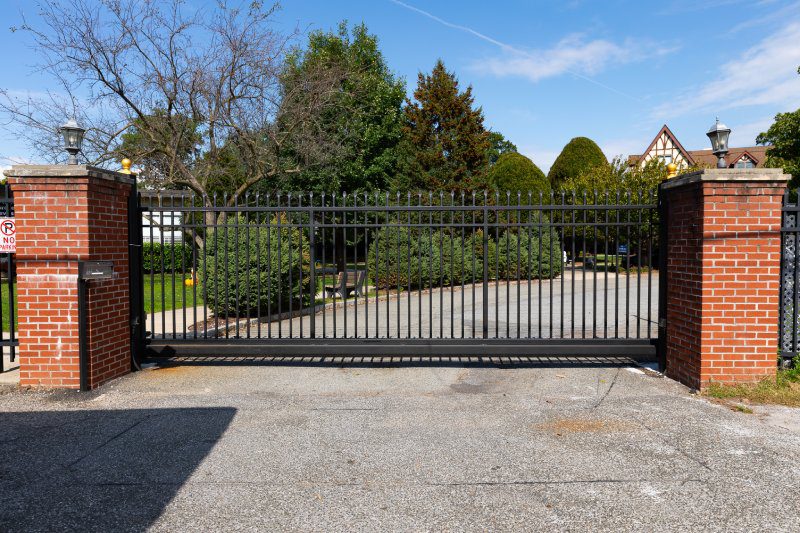 A Black Metal Modern Gate Paired with Red Brick.
