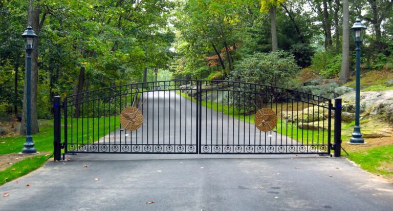 Curved black iron gate with gold golf course emblems.