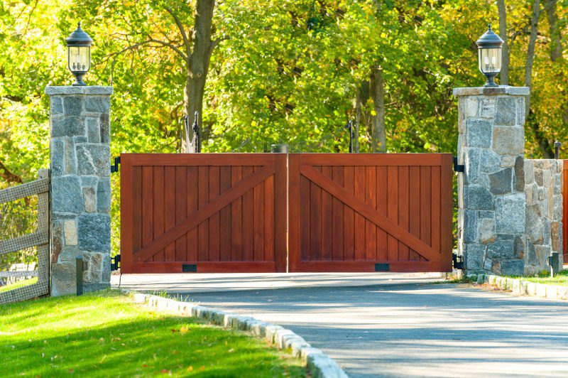 Mahogany Wood Gate Between Two Gray Stonework Columns.