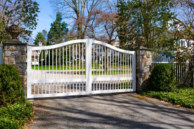 A White Gate Adds Interest to Warm Stone Columns.