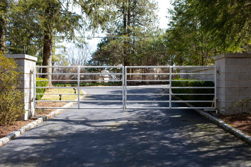 A Simple White Fence Stands Between Two Gray Stone Columns