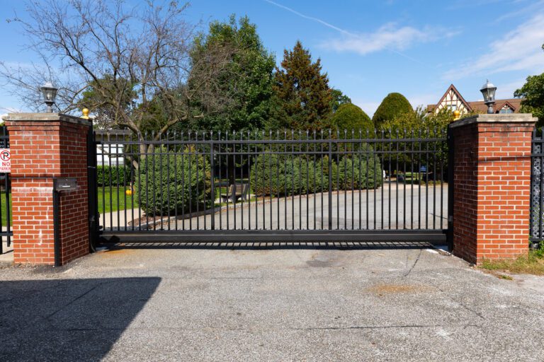 sliding metal commercial driveway gate with brick pillars
