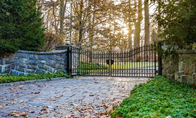 iron swing gate with detail and natural stone fencing