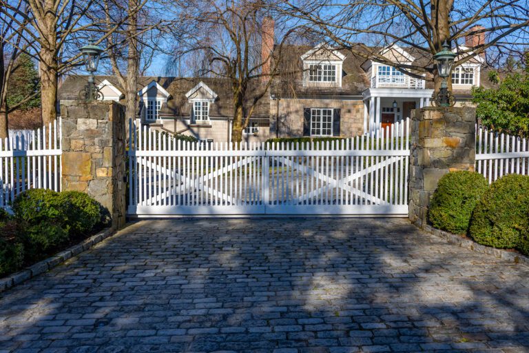 composite driveway gate with pickets and stone pillars