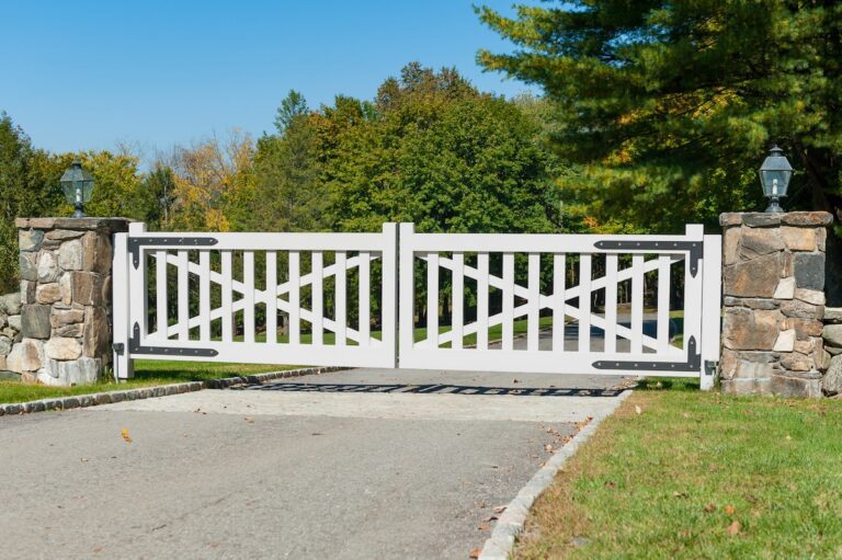 white wood driveway gate with spacing between slats and post rail design