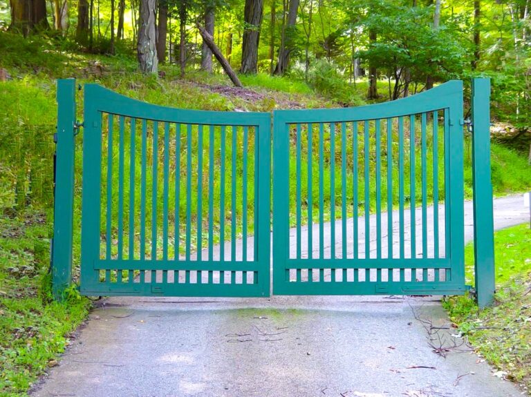green wood driveway gate with slight scallop and large spacing between slats