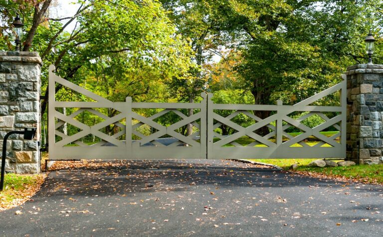 modern painted wood driveway gate with overlapping cross design and stone columns