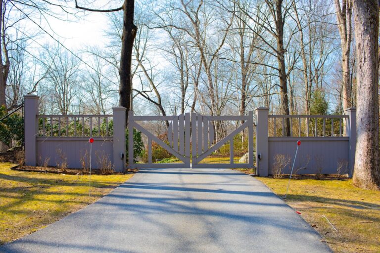 modern gray swing gate with custom circular slat design and matching fence