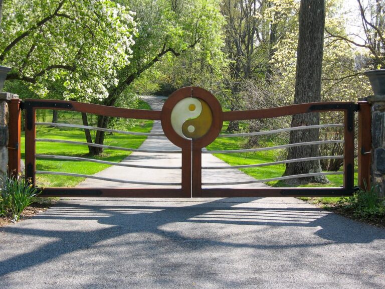 unique ying yang design wooden driveway gate with stone columns