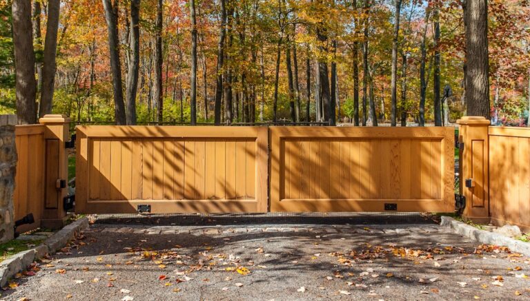 rectangular wooden swing gate with large vertical slats and matching fence