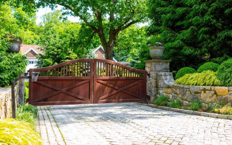 traditional wood driveway gate with arch and post rail design at an angle
