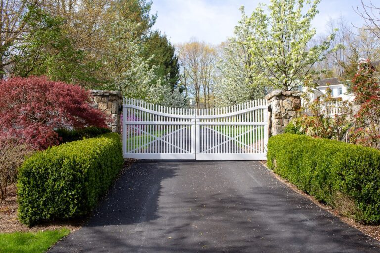 white wood gate with slim pickets and natural stone fence