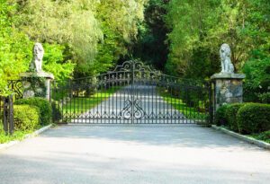 Custom driveway gate with stone columns and statues